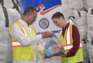 Minister of Foreign Affairs and Foreign Trade, Senator the Hon. Kamina Johnson Smith (right), looks at a care package being shown to her by Ambassador of the Dominican Republic to Jamaica, His Excellency Manuel Durán Pilarte. The package was among a 628-tonne shipment of humanitarian supplies donated by the Dominican Republican, which arrived on Wednesday (November 12) at Kingston Wharves Limited.