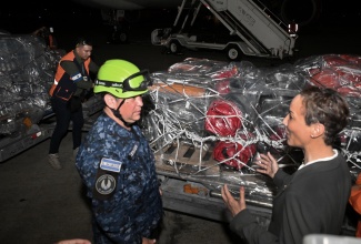 Minister of Foreign Affairs and Foreign Trade, Senator the Hon. Kamina Johnson Smith (right), engages in conversation with Lt. Col. Fernando Castañeda from the El Salvador Army, at the Norman Manley International Airport in Kingston. Lt. Col. Castañeda is among personnel who arrived alongside humanitarian aid from El Salvador on Sunday (November 2). El Salvador has sent three planes carrying humanitarian aid to assist with Jamaica’s recovery following Hurricane Melissa. 

