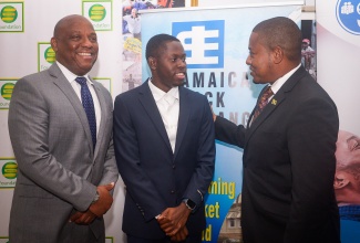 Minister of Agriculture, Fisheries and Mining, Hon. Floyd Green (right), speaks with Jamaica’s 100-metre World Champion, Oblique Seville (centre), at a press conference to officially launch the United Way of Jamaica’s Restoration and Rehabilitation Fund, held on Tuesday (November 11), at the offices of the Private Sector Organisation of Jamaica in St. Andrew. Sharing the moment is Chairman, Board of Governors, United Way of Jamaica, Dr. Devon Smith.

