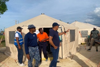 Minister of Health and Wellness, Dr. the Hon. Christopher Tufton (right, foreground), discusses the utilisation of space with Barbados Defence Force Emergency Medical Team (EMT) Leader, Lieutenant Commander Anderson Goodridge (second left), during his visit on Friday (November 28), to the Barbados Field Hospital, established on the grounds of the Savanna-la-Mar Public General Hospital in Westmoreland.
