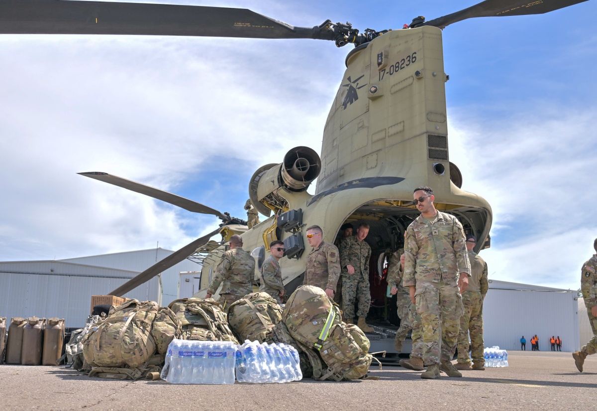 Members of the United Stated military unload relief supplies from one of three helicopters, which arrived in the island on Friday (October 31), at the Caribbean Military Academy School of Aviation in Kingston.