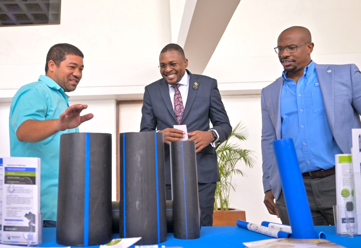 Minister without Portfolio in the Ministry of Economic Growth and Infrastructure Development with responsibility for Works, Hon. Robert Morgan (centre), and President, Incorporated Masterbuilders Association of Jamaica (IMAJ), Richard Mullings (right), in discussion with Divisional Manager for Waterworks, Isratech, Gregory Chin Loy, about the high-density polyethylene pipes manufactured in Jamaica, during the Incorporated Masterbuilders Association of Jamaica (IMAJ) seminar, held at the Jamaica Conference Centre in downtown Kingston, on November 25.

