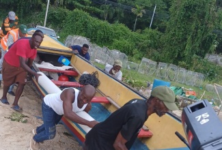 Fishermen at the Ocho Rios Fishing Village assist in getting a boat back into the water following the passage of Hurricane Melissa on October 28.