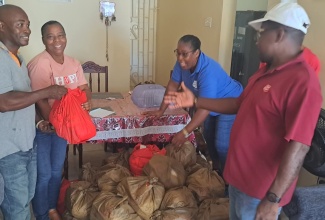  Volunteers from the Salvation Army in Cave Valley, St. Ann, getting ready to distribute care packages in the community.

