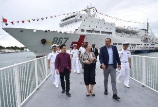 Minister of Foreign Affairs and Foreign Trade, Senator the Hon. Kamina Johnson Smith (centre); Minister of Health and Wellness, Dr. the Hon. Christopher Tufton (right) and China’s Ambassador to Jamaica, His Excellency Jinfeng Wang (left) engage in conversation as they disembark China’s navy hospital ship, the Silk Road Ark, in Port Royal on Monday (December 8). They are accompanied by members of the ship’s crew. The Silk Road Ark travelled from Montego Bay where it spent three days treating patients.