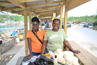 Vendors at Border in St. Elizabeth, Opal Wedderburn (left) and Nadine Brown (right) smile for the camera, showing off their bammies and other items for sale at their newly rebuilt stalls. Sellers at the popular spot have expressed gratitude to the Government after the Ministry of Industry, Investment and Commerce rebuilt 44 stalls in the area at a cost of approximately $20 million. The project forms part of a wider government initiative to support micro, small and medium-sized enterprises (MSMEs) in parishes that were significantly impacted by the major storm.

