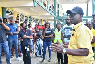 Minister of Local Government and Community Development, Hon. Desmond McKenzie (right), speaks to residents sheltering at Petersfield High School in Westmoreland, during a visit to the location on Wednesday (December 3). 

