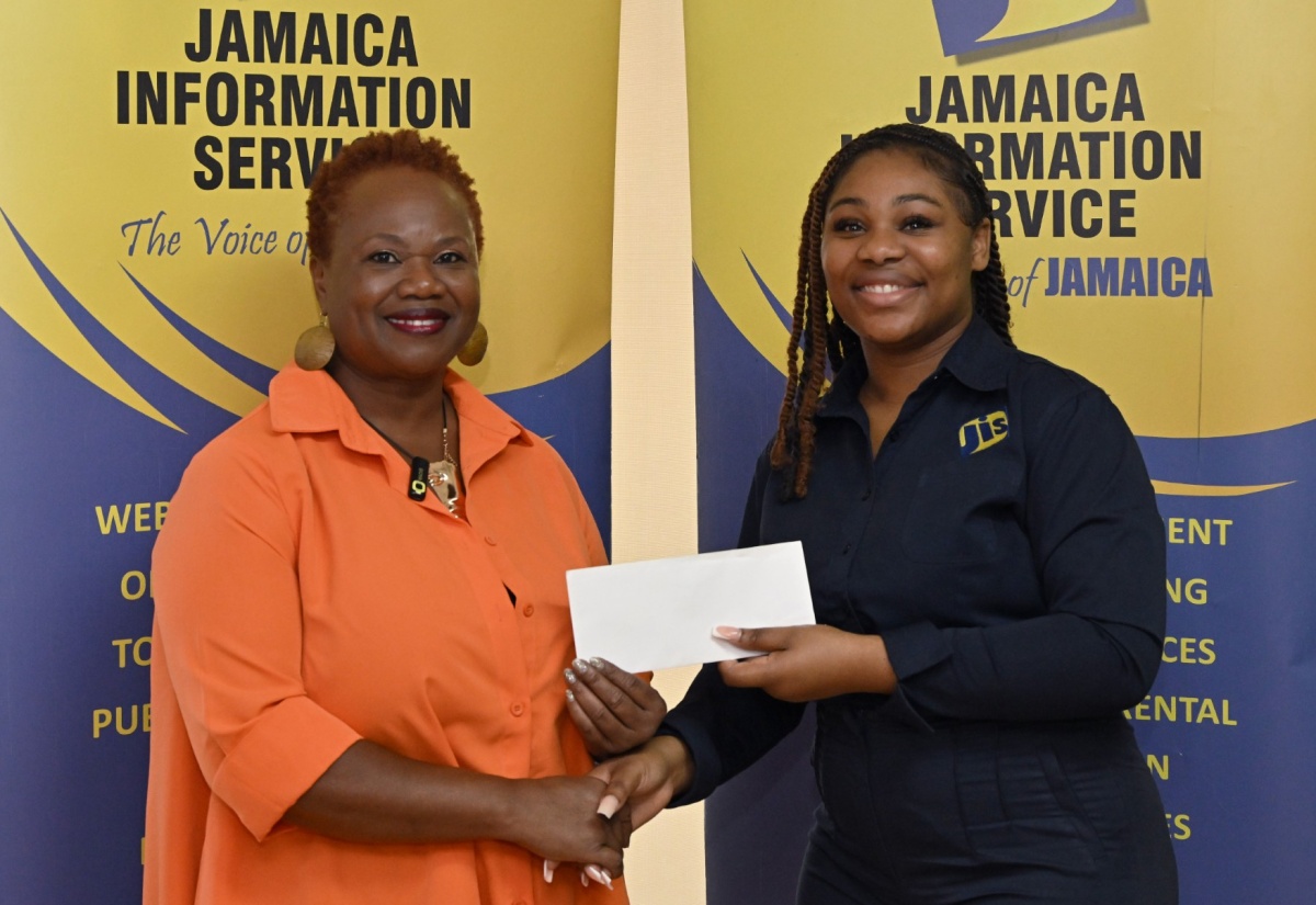 Special Projects Officer at the Jamaica Information Service (JIS), Romona Geohaghan (right), receives a donation from Founder of the Dr. Sue and You Charitable Foundation, Dr. Susan Davis, towards the annual Christmas treat and relief efforts organised by the JIS on behalf of the Mount Olivet Boys