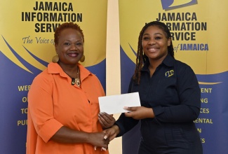 Special Projects Officer at the Jamaica Information Service (JIS), Romona Geohaghan (right), receives a donation from Founder of the Dr. Sue and You Charitable Foundation, Dr. Susan Davis, towards the annual Christmas treat and relief efforts organised by the JIS on behalf of the Mount Olivet Boys