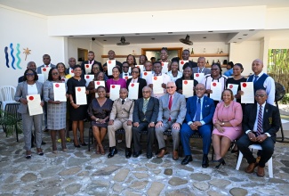 Minister of Justice and Constitutional Affairs, Hon. Delroy Chuck (seated centre) and Custos of St. Mary, Hon. Errol Johnson (seated, third left), are surrounded by newly minted Justices of the Peace (JPs) of St. Mary, during the commissioning ceremony held at the Cabarita Inn & Grill in Port Maria on December 3.