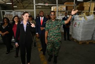 Minister of Foreign Affairs and Foreign Trade, Hon. Kamina Johnson Smith (left), looks on as Colonel General Staff, Guyana Defence Force, Captain (Coast Guard), Vernon Burnette, points out hurricane relief items donated by Guyana, including roofing material for the rebuilding of 200 roofs. The items were handed over on Tuesday (December 9) at a warehouse facility on Marcus Garvey Drive in Kingston. Observing in the background are Honorary Consul for Guyana to Jamaica, Indera Persaud and Director General, Office of Disaster Preparedness and Emergency Management (ODPEM), Commander Alvin Gayle.

