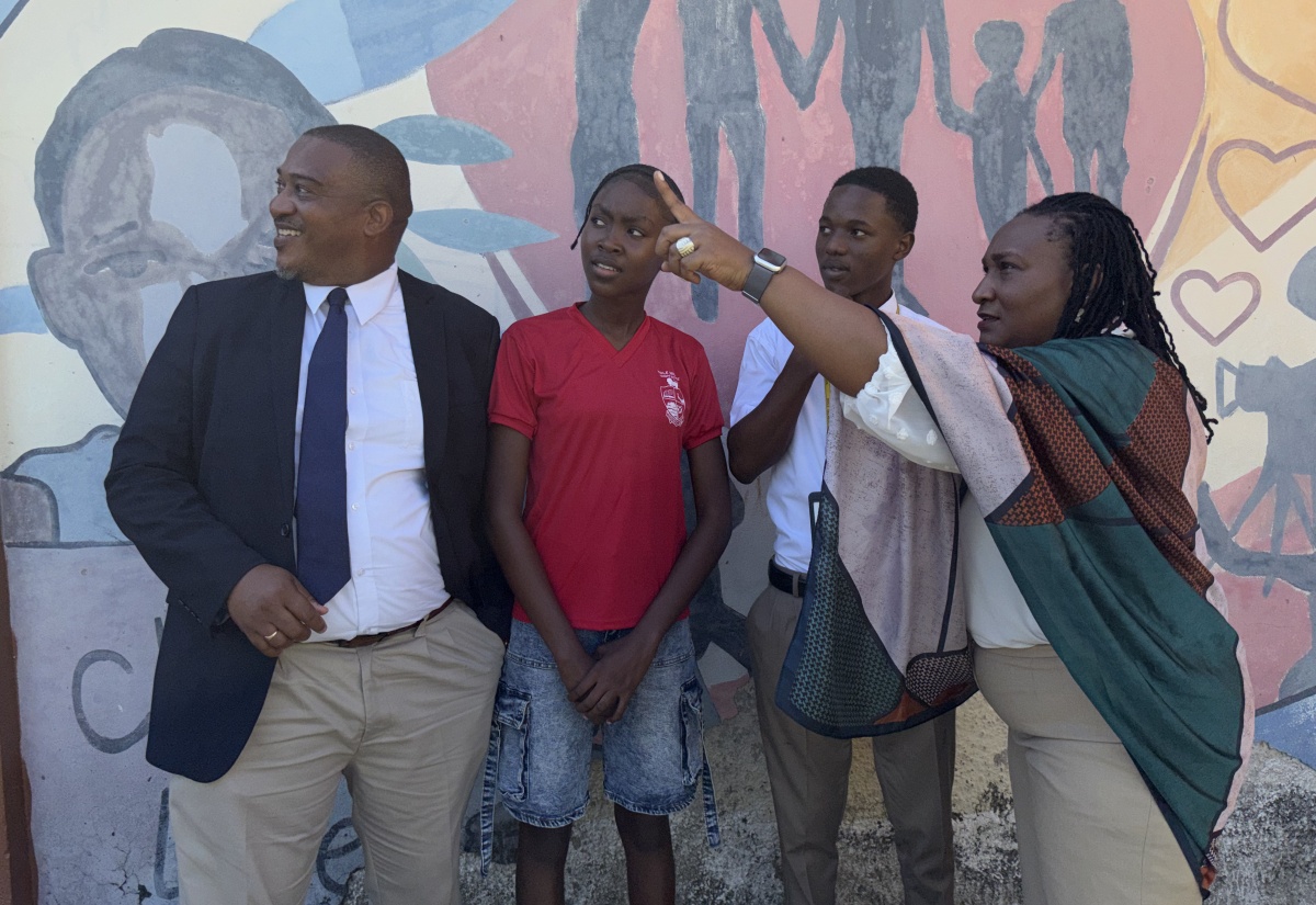 National Coordinator, School Safety and Security Branch in the Ministry of Education, Skills, Youth and Information, Richard Troupe (left), looks on as Principal, Haile Selassie High School, Anniona Jones (right) points out something of interest, during a break from a recent conflict resolution and gender-based violence training session at the school in Kingson. Head girl, Jecola Watson (second left) and head boy, Jaheim Pinnock, also observe.


