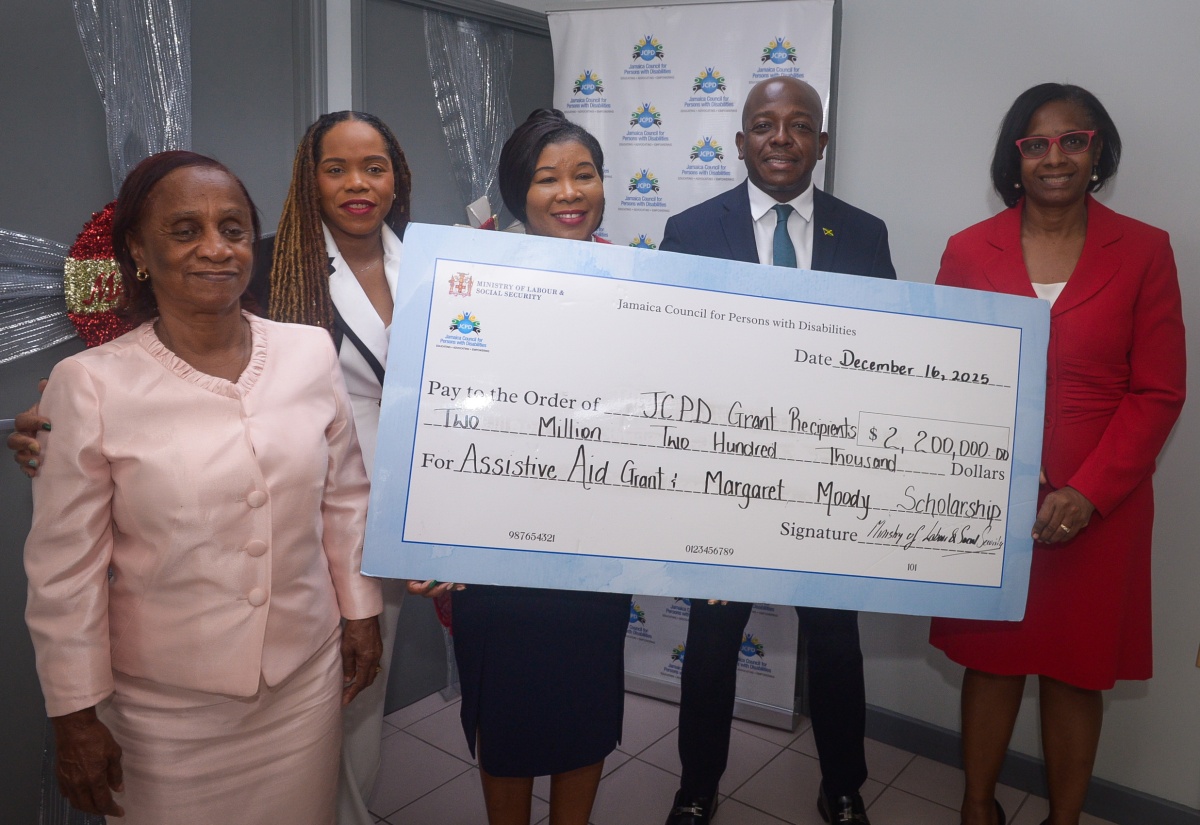 Minister of Labour and Social Security, Hon. Pearnel Charles Jr. (second right), participates in the presentation of a cheque valued at $2,200,000, representing the Assistive Aid Grant and the Margaret Moody Scholarship. Joining him (from left) are Chairperson of the Jamaica Council for Persons with Disabilities (JCPD) Social and Economic Empowerment Committee, Gloria Goffe-Smallwood; Communications Advisor to the Minister, Rochelle Mitchell; JCPD Acting Executive Director, Desreen Boothe; and Permanent Secretary in the Ministry of Labour and Social Security, Dione Jennings. The presentation took place during the Handover Ceremony for the Assistive Aid Grant and the Margaret Moody Scholarship at the JCPD Head Office in Kingston on Tuesday (December 16).

