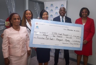 Minister of Labour and Social Security, Hon. Pearnel Charles Jr. (second right), participates in the presentation of a cheque valued at $2,200,000, representing the Assistive Aid Grant and the Margaret Moody Scholarship. Joining him (from left) are Chairperson of the Jamaica Council for Persons with Disabilities (JCPD) Social and Economic Empowerment Committee, Gloria Goffe-Smallwood; Communications Advisor to the Minister, Rochelle Mitchell; JCPD Acting Executive Director, Desreen Boothe; and Permanent Secretary in the Ministry of Labour and Social Security, Dione Jennings. The presentation took place during the Handover Ceremony for the Assistive Aid Grant and the Margaret Moody Scholarship at the JCPD Head Office in Kingston on Tuesday (December 16).

