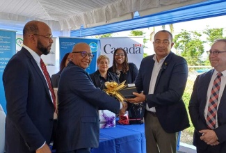Health and Wellness Minister, Dr. the Hon. Christopher Tufton (second right), accepts Electronic Immunisation Registry (EIR) equipment from Monitoring and Evaluation Specialist at UNICEF, Dr. Paul Edwards (second left), during a handover ceremony held at the St. Ann Health Department in St. Ann on December 11.  Looking on are Mayor of St. Ann
