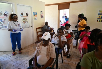 Head of Mission is Possible, Dr. Ashley Tabi (left), engages patients at the Orange Hill Health Clinic in St. Ann, on Wednesday, December 3.

