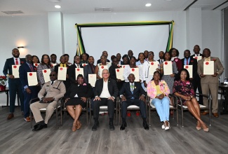 Minister of Justice and Constitutional Affairs, Hon. Delroy Chuck (seated, third left), is surrounded by the 26 newly installed Justices of the Peace (JP) for Hanover at the commissioning ceremony held at the Grand Palladium hotel in the parish on Friday (Dec.19).Custos of Hanover, the Hon. Lennox Anderson-Jackson is seated third right.