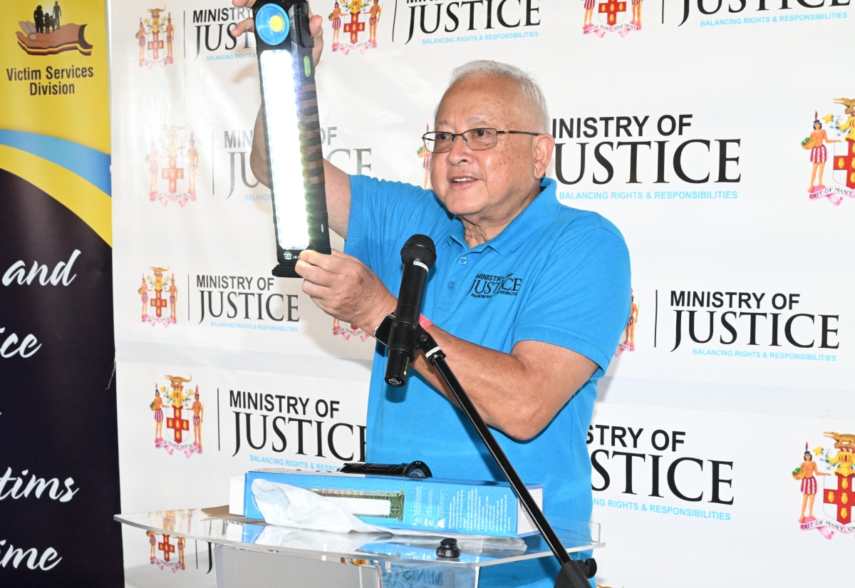 Minister of Justice and Constitutional Affairs, Hon. Delroy Chuck, displays one of the solar lights presented to residents of Hanover during the Ministry