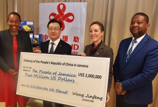 Minister of Foreign Affairs and Foreign Trade, Senator the Hon. Kamina Johnson Smith (second right), receives a cheque valued at US$2 million from Ambassador of the People’s Republic of China to Jamaica, His Excellency Wang Jinfeng (second left), during the recent handover of relief supplies at the Ministry’s head office on Port Royal Street, downtown Kingston. Joining them are Permanent Secretary in the Ministry, Ambassador Sheila Sealy Monteith (left), and Director General of the Office of Disaster Preparedness and Emergency Management (ODPEM), Commander Alvin Gayle.

