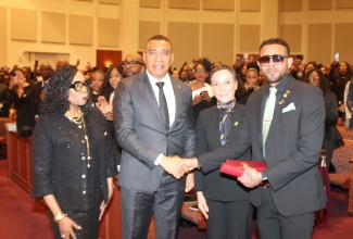 Prime Minister, Dr. the Most Hon. Andrew Holness (second left), presents the Order of Distinction (Commander Class) insignia to Omar Wilson, widower of late Consul General of Jamaica to New York, Alsion Roach Wilson, during the celebration of life service held at the Community Baptist Church of Englewood, New Jersey, on December 5. Mrs. Roach Wilson was conferred with the national honour earlier this year, in recognition of her outstanding contributions to Jamaica’s development in education, technology, and the strengthening of healthcare capacity. Looking on (from left) are United States Congresswoman, Yvette D. Clarke, and Minister of Foreign Affairs and Foreign Trade, Senator the Hon. Kamina Johnson Smith.