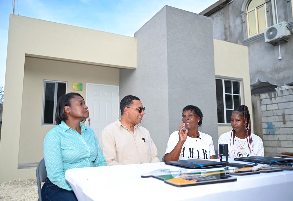 Prime Minister, Dr. the Most Hon. Andrew Holness, listens attentively as New Social Housing Programme (NSHP) beneficiary, Beverly Barnaby-Moo-Young (second right), shares her journey to home ownership. The occasion was the official handover of her new unit in Savanna-la-Mar, Westmoreland, on November 28. Also pictured are (from left) Permanent Secretary in the Ministry of Economic Growth and Infrastructure Development, Arlene Williams, and Mrs. Barnaby Moo-Young’s daughter, Natasha Moo-Young.


