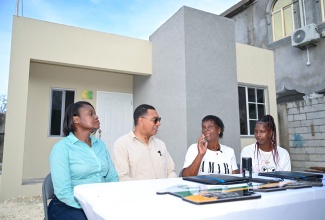 Prime Minister, Dr. the Most Hon. Andrew Holness, listens attentively as New Social Housing Programme (NSHP) beneficiary, Beverly Barnaby-Moo-Young (second right), shares her journey to home ownership. The occasion was the official handover of her new unit in Savanna-la-Mar, Westmoreland, on November 28. Also pictured are (from left) Permanent Secretary in the Ministry of Economic Growth and Infrastructure Development, Arlene Williams, and Mrs. Barnaby Moo-Young’s daughter, Natasha Moo-Young.

