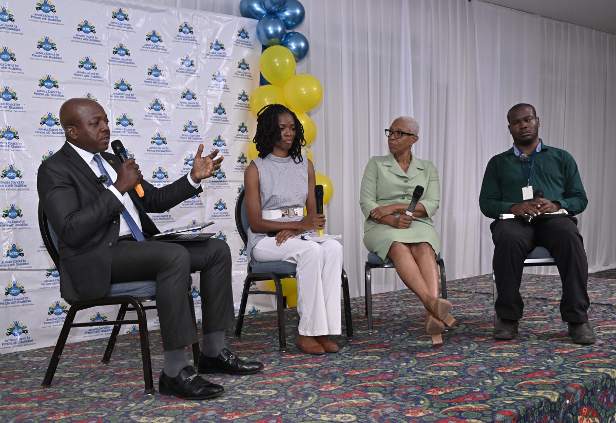 Minister of Labour and Social Security, Hon. Pearnel Charles Jr. (left), addresses a public forum at the Kingston Summit business complex on Wednesday (December 3) to mark International Day for Persons with Disabilities 2025, observed under the theme ‘Rebuilding an Accessible Jamaica for All’. Also pictured (from second left) are Executive Member of the Jamaica Association of Architects, Sana Williams; Executive Director of the Jamaica Association for Persons with Intellectual Disabilities, Marilyn McKoy; and forum panellist, Alister McLean.


