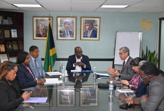 Minister of Labour and Social Security, Hon. Pearnel Charles Jr. (head of table), listens to a presentation from United Nations Children Fund (UNICEF) Regional Director for Latin America and the Caribbean, Roberto Benes (fourth right), during a courtesy call by a UNICEF delegation at the Ministry’s North Street offices in Kingston on Friday (Dec. 12). The Ministry’s team included Acting Permanent Secretary, Dione Jennings (second left); and State Minister, Hon. Donovan Williams (third left).