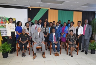 Minister of Justice and Constitutional Affairs, Hon. Delroy Chuck (seated second left), and Custos of Kingston, Hon. Steadman Fuller (seated second right), are surrounded by newly commissioned Justices of the Peace (JP) for the parish, during a ceremony held on Thursday (Dec. 4) at Kingston Bookshop, downtown Kingston. Sharing the moment are Interim Chairman, Justices of the Peace of Jamaica, Kingston Association, Cynthia Cooke (seated left) and instructor and Puisne Judge, Sonia Bertram Linton (seated right). 