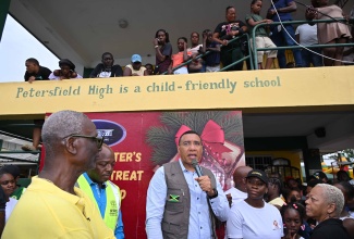 Prime Minister, Dr. the Most Hon. Andrew Holness (centre), addresses residents at the Petersfield High School emergency shelter in Westmoreland during a Christmas treat hosted at the facility on December 13. Listening are Minister of Local Government and Community Development, Hon. Desmond McKenzie (left), and Minister of Labour and Social Security, Hon. Pearnel Charles Jr. (second left).

