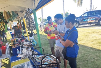 Caption: Patrons browse locally made products at one of the Local Economic Initiative (LEI) booths during the Social Development Commission (SDC) St. James Local Economic Development (LED) Social Services Fair, at Harmony Beach Park, on Saturday, December 20. 

