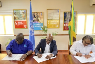 United Nations Resident Coordinator, Dennis Zulu (left); Minister of Labour and Social Security, Hon. Pearnel Charles Jr., and Executive Director, Jamaica Council for Persons with Disabilities, Dr. Christine Hendricks, sign the Joint Declaration of Intent to strengthen disability inclusion, at the United Nations Development Programme (UNDP) Conference Room in Kingston, recently. 