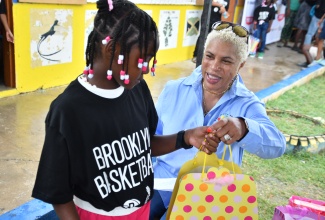 Chief Executive Officer and Founder of New York based Pollyanna Project charity , Donna Moore- Stewart hands out gifts during a Christmas treated hosted by the organization at the Parottee Primary School in St. Elizabeth on December 23.