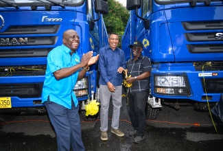 Prime Minister, Dr. the Most Hon. Andrew Holness (centre); Minister of Local Government and Community Development, Hon. Desmond McKenzie (right); and Executive Director of the National Solid Waste Management Authority (NSWMA), Audley Gordon, celebrate the addition of 10 new tipper trucks to the NSWMA’s fleet. The trucks were handed over during a ceremony at the NSWMA’s headquarters in Kingston on Tuesday (December 23).

