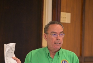 Minister of Energy, Transport and Telecommunications, Hon. Daryl Vaz, shows a signed copy of the Jamaica Public Service (JPS) loan agreement, during a press conference at the PCJ Building in New Kingston, on December 16. Cabinet has approved a US$150-million loan to the JPS to facilitate restoration efforts without extending the current existing licence, which expires in 2027.

