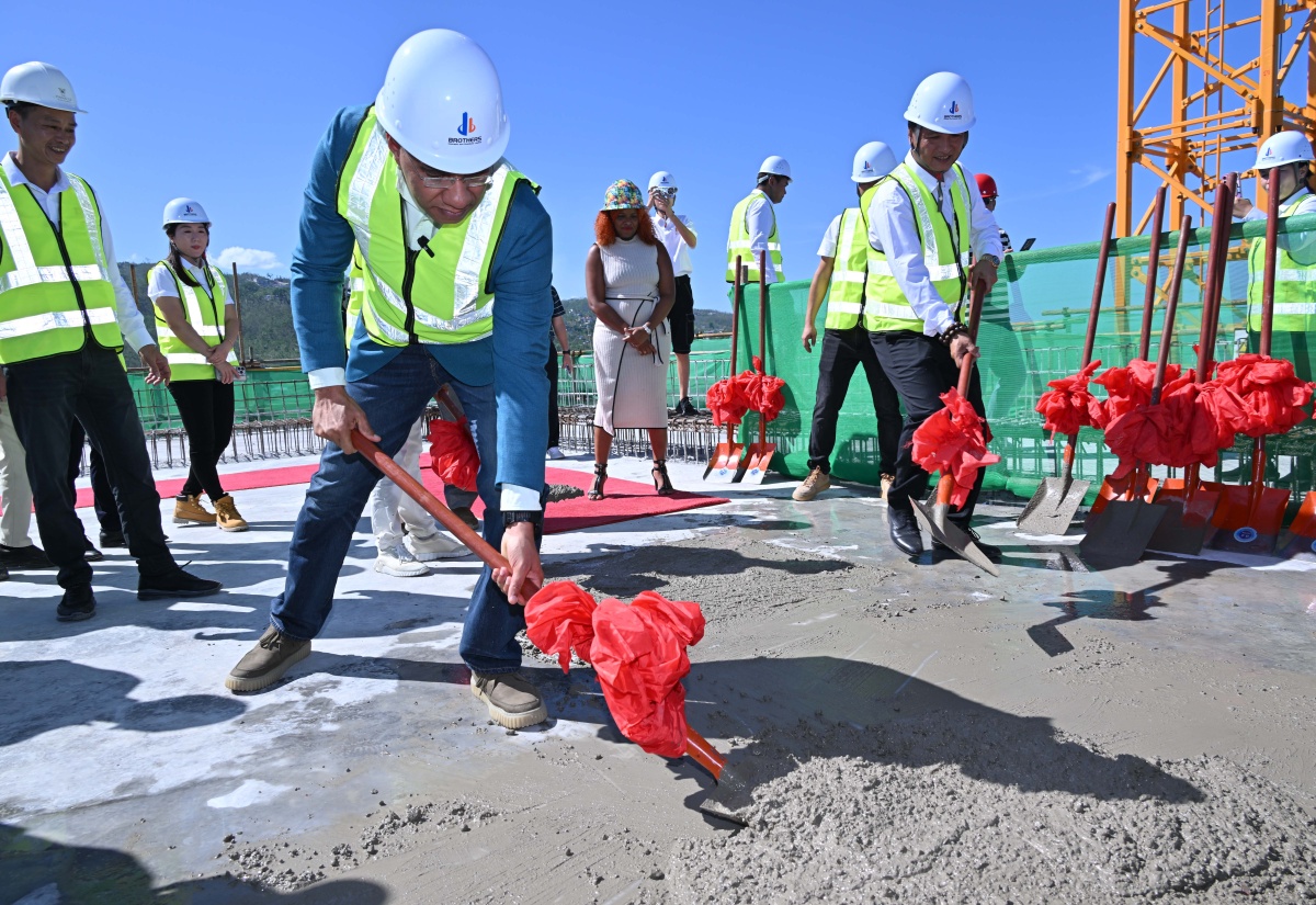 Prime Minister, Dr. the Most Hon. Andrew Holness, pours the symbolic concrete on the top floor of the 28-storey Pinnacle luxury development in St. James, on December 10.