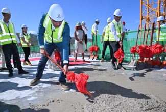Prime Minister, Dr. the Most Hon. Andrew Holness, pours the symbolic concrete on the top floor of the 28-storey Pinnacle luxury development in St. James, on December 10.