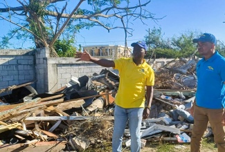 Executive Director of the National Solid Waste Management Authority (NSWMA), Audley Gordon (left), in discussion with Regional Operations Manager at SPM Waste Management Ltd., Sheldon Smith, about clean-up operations in  Black River, St. Elizabeth, on Monday (December 29), following the passage of Hurricane Melissa.

