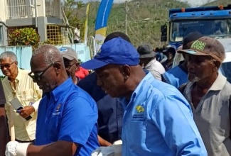 Minister of Local Government and Community Development, Hon. Desmond McKenzie (left), and Executive Director of the National Solid Waste Management Authority (NSWMA), Audley Gordon, prepare to participate in post-hurricane cleanup activities in Darliston, Westmoreland, on December 5.

