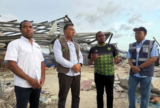 Prime Minister, Dr. the Most Hon. Andrew Holness (second left), with General Manager of the Urban Development Corporation (UDC), Robert Honeyghan; Minister of Agriculture, Fisheries, and Mining, Hon. Floyd Green (third left), and Chairman of the UDC, Norman Brown, as they discuss the UDC’s lead role in clean-up efforts in Black River, St. Elizabeth, on December 13.