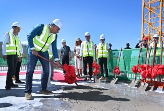 Prime Minister, Dr. the Most Hon. Andrew Holness,  pours the symbolic final concrete mix on the 28th floor of the landmark Pinnacle – Jamaica’s tallest building – in Montego Bay, St. James, on December 10.

