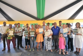 Prime Minister, Dr. the Most Hon. Andrew Holness (background centre) shares a moment with newly minted landowners after a land titling ceremony held at the Lacovia Community Centre in St. Elizabeth on Friday ( December 12). Also participating in the ceremony were Member of Parliament for St. Elizabeth North West, Andrew Morris (left) and Minister of State in the Ministry of Agriculture, Fisheries and Mining, Hon. Franklin Witter (fifth right). 