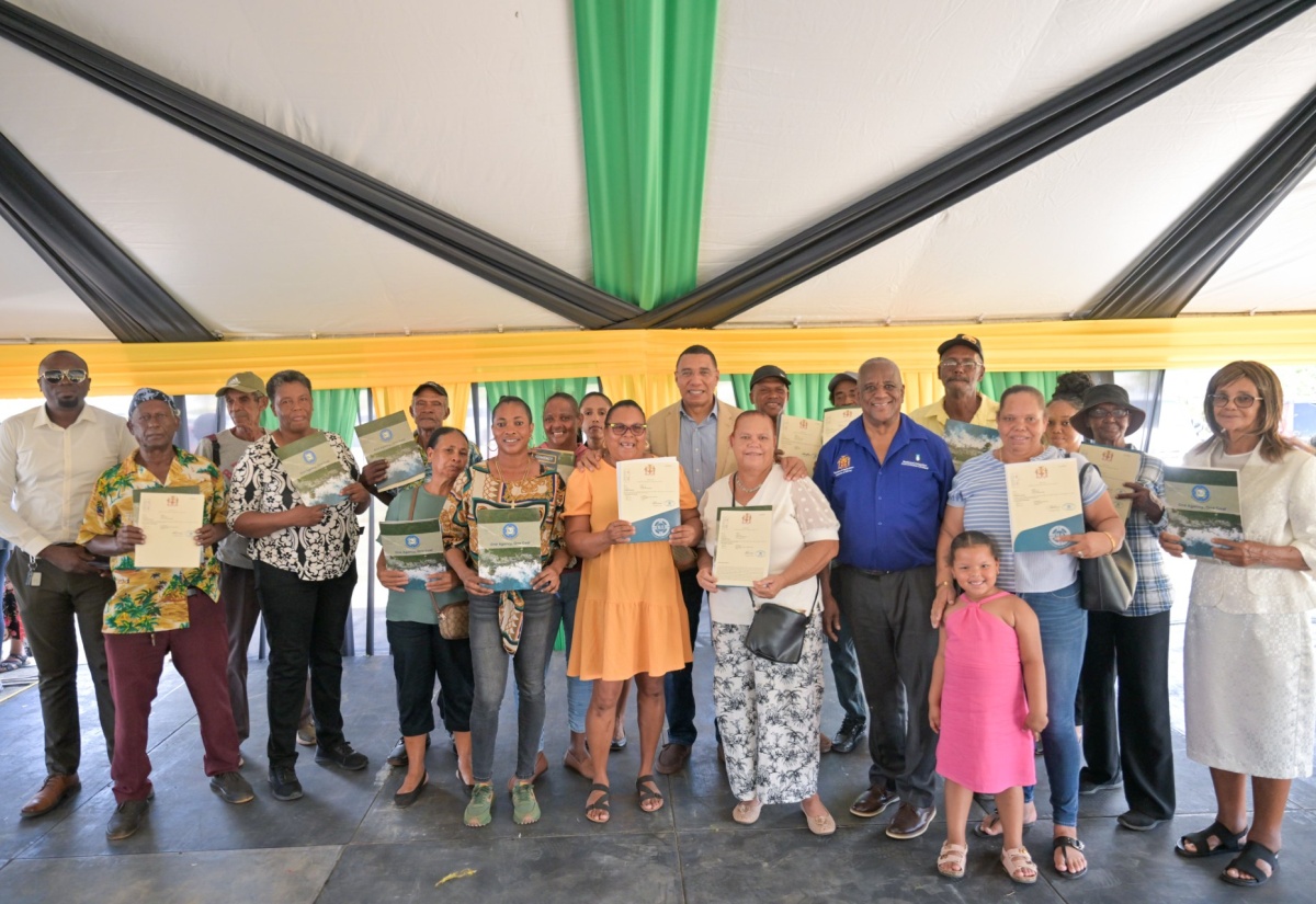 Prime Minister, Dr. the Most Hon. Andrew Holness (background centre) shares a moment with newly minted landowners after a land titling ceremony held at the Lacovia Community Centre in St. Elizabeth on Friday ( December 12). Also participating in the ceremony were Member of Parliament for St. Elizabeth North West, Andrew Morris (left) and Minister of State in the Ministry of Agriculture, Fisheries and Mining, Hon. Franklin Witter (fifth right). 