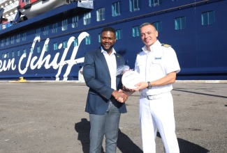 Mayor of Montego Bay, Councillor Richard Vernon (left),  is presented with a gift by Captain of the Mein Schiff, Georgios Dimou, on arrival of the vessel at the Montego Bay Port in St. James on November 24. The Mein Schiff is the first vessel to call at the port since the passage of Hurricane Melissa on October 28.
