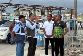 Prime Minister, Dr. the Most Hon.  Andrew Holness (second left), has the full attention of Minister of Agriculture, Fisheries and Mining, Hon. Floyd Green (right); Chairman of the Urban Development Corporation (UDC), Norman Brown (left), and General Manager of the UDC, Robert Honeyghan, as they discuss the UDC’s lead role in clean-up efforts in Black River, St. Elizabeth, during a visit on December 13.

