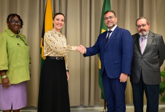 Minister of Foreign Affairs and Foreign Trade, Senator the Hon. Kamina Johnson Smith (second left), shakes hands with Chargé d’Affaires, Embassy of the Federative Republic of Brazil, Minister Eric Sogocio (second right), during the handover ceremony for humanitarian items donated by Brazil in aid of Hurricane Melissa relief and recovery efforts at the Ministry’s Port Royal Street offices in downtown Kingston on Tuesday (January 13). Sharing the moment are Senior Director, Mitigation, Planning and Research, Office of Disaster Preparedness and Emergency Management (ODPEM), Michelle Edwards (left), and Representative of the Embassy of the Federative Republic of Brazil, Counsellor Arnaldo Salbert.

