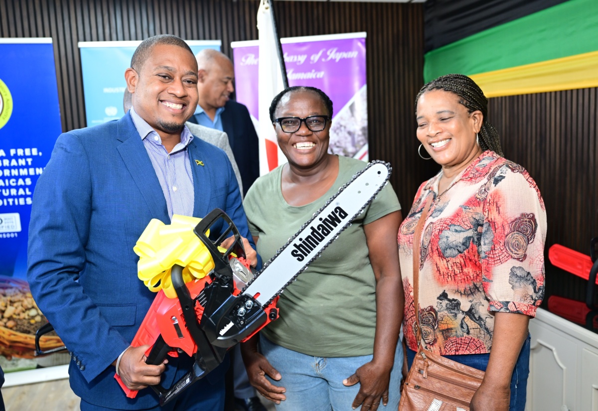Minister of Agriculture, Fisheries and Mining, Hon. Floyd Green (left), shares a photo opportunity with coffee farmer Miriam McDonald (centre) and Bernice Barrett (right), while holding one of the professional-grade chainsaws during the handover of power equipment to farmers affected by Hurricane Melissa, at the Jamaica Commodities Regulation Authority (JACRA), 1 Willie Henry Drive, off Marcus Garvey Drive in Kingston, on January 21. The equipment was provided through a United Nations Industrial Development Organization (UNIDO) project, funded by the Government of Japan.

