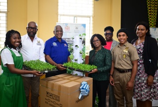 Minister of State in the Ministry of Agriculture, Fisheries and Mining, Hon. Franklyn Witter (third left), presents a vertical hydroponic tower to Vice Principal of Manchester High School, Hillary Morgan (fourth left), during a ceremony held at the school on January 22. Others pictured (from left) are Form Captain, Demarco-De Pryce; Chief Executive Officer at the Rural Agricultural Development Authority (RADA), Garnet Edmondson; Head of the Natural Science Department at the school, Donna Reid;  Form Captain, Liaje Waysome, and Agricultural Science Teacher, Suzanne Samuels-Dixon.

