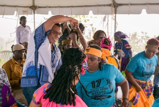Prime Minister, Dr. the Most Hon. Andrew Holness (left), dances with the Charles Town Maroons during the ceremony for the 288th anniversary of the 1738 Treaty between the Leeward Maroons and the British, as well as the birthday of Chief Kojo, in Accompong Town, St. Elizabeth, on Tuesday (January 6).

