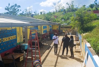 Parliamentary Secretary in the Ministry of Education, Skills, Youth and Information, Senator Marlon Morgan (centre); Regional Director at the Ministry for Region Five, Susan Nelson Smith (right), and Managing Director at the Southern Contracting Company, Dameon Sinclair, look at a section of the Clapham Primary and Infant School in St. Elizabeth, which was damaged during the passage of Hurricane Melissa last year. The occasion was a visit to schools in the parish by Senator Morgan and other stakeholders on Thursday (January 9). 

